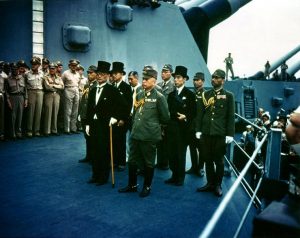 Surrender of Japan, Tokyo Bay, 2 September 1945: Japanese representatives on board USS Missouri (BB-63) during the surrender ceremonies. Standing in front are: Foreign Minister Mamoru Shigemitsu (wearing top hat) and General Yoshijiro Umezu, Chief of the Army General Staff. Behind them are three representatives each of the Foreign Ministry, the Army and the Navy. They include, in middle row, left to right: Major General Yatsuji Nagai, Army; Katsuo Okazaki, Foreign Ministry; Rear Admiral Tadatoshi Tomioka, Navy; Toshikazu Kase, Foreign Ministry, and Lieutenant General Suichi Miyakazi, Army. In the back row, left to right (not all are visible): Rear Admiral Ichiro Yokoyama, Navy; Saburo Ota, Foreign Ministry; Katsuo Shiba, Navy, and Kaziyi Sugita, Army. (Identities those in second and third rows are from an annotated photograph in Naval Historical Center files.) Date 2 September 1945 Source Naval Historical Center Photo # USA C-2719. Photograph from the Army Signal Corps Collection in the U.S. National Archives.