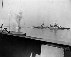 A heavy German coast artillery shell falls between USS Texas (BB-35), in the background, and USS Arkansas (BB-33), while the two battleships were engaging Battery Hamburg during the bombardment of Cherbourg, France, 25 June 1944. Photographed from the USS Arkansas. Official U.S. Navy Photograph, now in the collections of the National Archives.