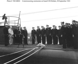 After six months of sea trials in Lake Michigan, commissioning ceremonies take place on board USS Robalo on September 28, 1943. There was no St. Lawrence seaway until the 1960's so the fresh water submarines had to be transported down the Mississippi River. Gato class submarines had a minimum draft of 12 feet but could be transported through Chicago and the 9-foot-deep Chain of Rocks Channel near the confluence of the Mississippi and Missouri Rivers by carrying the submarines in a floating dry dock.