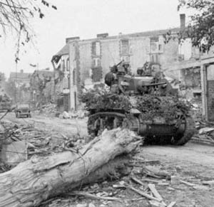 Light Tank M5 passes through the wrecked streets of Coutances in Normandy.