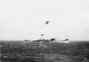 Joint Australian-United States naval Task Group 17.3 under air torpedo attack by Imperial Japanese Navy land-based bombers during the Battle of the Coral Sea on May 7, 1942. A Japanese Mitsubishi G4M Type 1 bomber flies past the cruiser HMAS Australia. The smoke astern of the cruiser marks where another Japanese bomber has been shot down. Date 7 May 1942