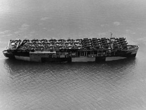 The U.S. Navy escort carrier USS Long Island (CVE-1) photographed on 10 June 1944 by a plane from Naval Air Station, Alameda, California (USA). She has 21 Grumman F6F fighters, 20 Douglas SBD scout bombers and two Grumman J2F utility planes parked on her flight deck. The ship is painted in camouflage Measure 32, Design 9a.