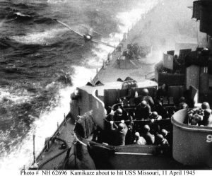 About to be hit by a Japanese A6M "Zero" Kamikaze, while operating off Okinawa on 11 April 1945. The plane hit the ship's side below the main deck, causing minor damage and no casualties on board the battleship. A 40mm quad gun mount's crew is in action in the lower foreground. The photographer has been identified as Seaman Len Schmidt. Collection of Fleet Admiral Chester W. Nimitz.