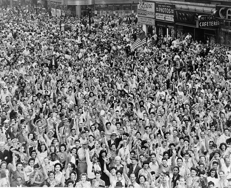 Crowd of people, many waving, in Times Square on V-J Day at time of announcement of the Japanese surrender in 1945 / World-Telegram photo by Dick DeMarsico. Date 14 August 1945