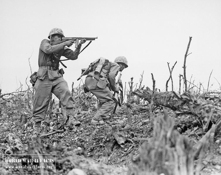 A U.S. Marine from the 2nd Battalion, 1st Marines on Wana Ridge provides covering fire with his Thompson submachine gun, 18 May 1945.